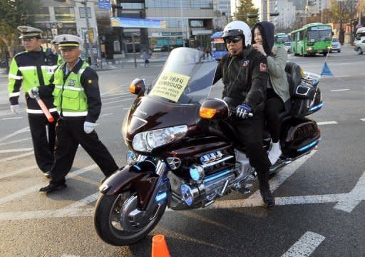 A South Korean motor rider carries a student taking the College Scholastic Ability Test, a standardised exam for college entrance, near a high school in Seoul in 2011. Military training was suspended, flights rescheduled and emergency calls reserved for latecomers as hundreds of thousands of South Korean students sat a crucial college entrance examination