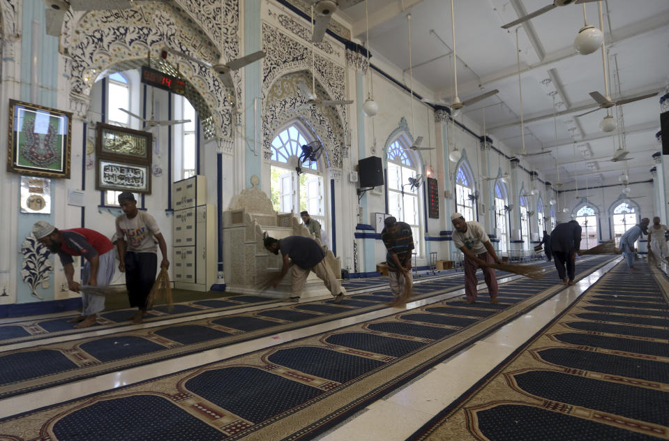 Volunteers clean the main hall at a mosque ahead of the upcoming Muslim fasting month of Ramadan, in Karachi, Pakistan, Saturday, April 2, 2022. The Muslim holy month of Ramadan — when the faithful fast from dawn to dusk — began at sunrise Saturday in much of the Middle East, where Russia's invasion of Ukraine has sent energy and food prices soaring. (AP Photo/Fareed Khan)