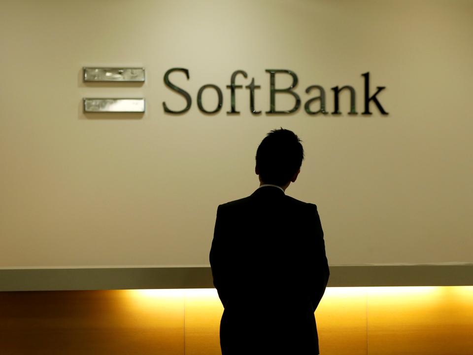 FILE PHOTO: A man looks at the logo of SoftBank Group Corp at the company's headquarters in Tokyo, June 30, 2016.   REUTERS/Toru Hanai/File Photo