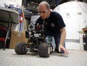 Matt Cross, an engineer with Crew 125 EuroMoonMars B mission, works on a rover at the Mars Desert Research Station (MDRS) outside Hanksville in the Utah desert March 3, 2013. The MDRS aims to investigate the possibility of a human exploration of Mars and uses the Utah desert's Mars-like terrain to simulate working conditions on the red planet. Scientists, students and enthusiasts work together developing field tactics and studying the terrain. All outdoor exploration is done wearing simulated spacesuits and carrying air supply packs and crews live together in a small communication base with limited amounts of electricity, food, oxygen and water. Everything needed to survive must be produced, fixed and replaced on site. Picture taken March 3, 2013. REUTERS/Jim Urquhart