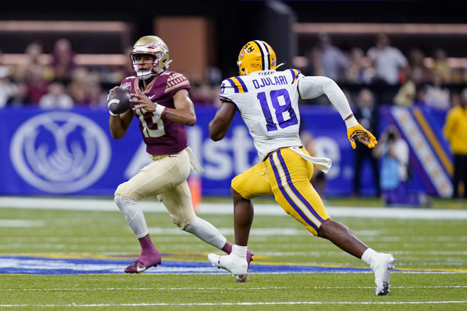 Florida State quarterback Jordan Travis, 13, beats LSU defensive end BJ Ojulari, 18, during the first half of an NCAA college football game in New Orleans on Sunday, Sept. 4, 2022. scrambling under pressure from  (AP Photo/Gerald Herbert)