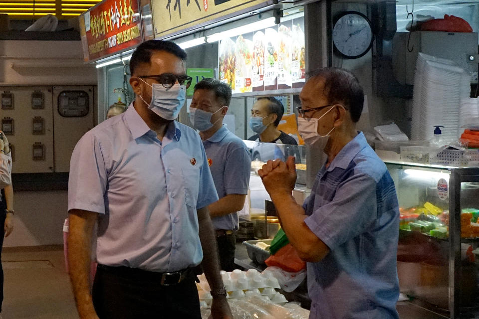 Workers’ Party chief Pritam Singh speaking with a hawker during a party walkabout in Bedok North on 27 June 2020. (PHOTO: Dhany Osman / Yahoo News Singapore)