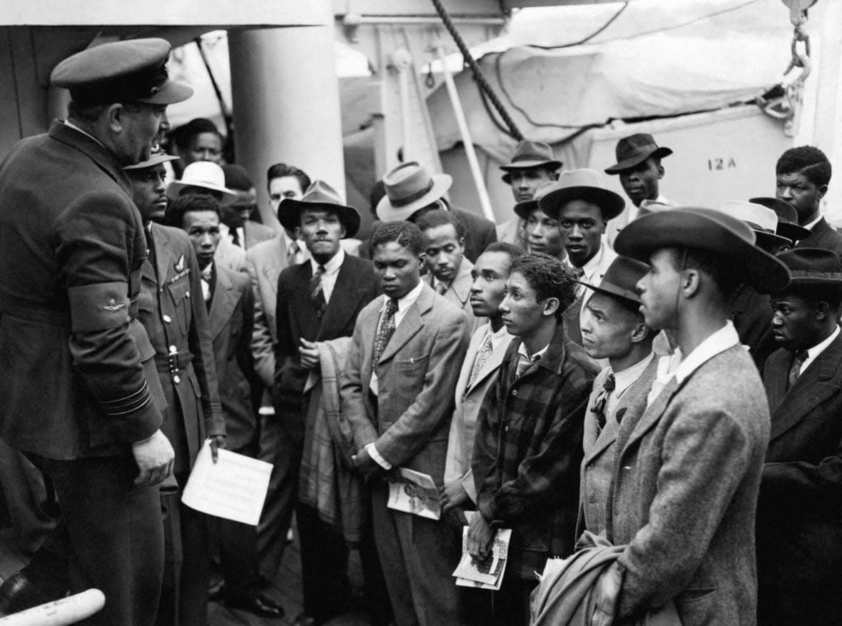 People arriving from the Caribbean are welcomed by RAF officials from the Colonial Office after the ex-troopship HMT Empire Windrush docks, at Tilbury, England, June 22, 1948. (PA via AP, File)
