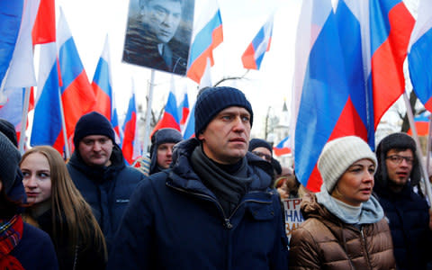 Opposition leader Alexei Navalny, who has been barred from the presidential race, marches in front of Mr Nemtsov's portrait - Credit: Sefa Karacan/Anadolu Agency/Getty Images