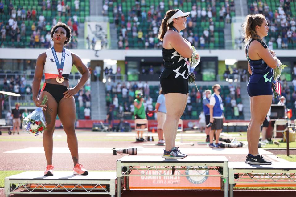 EUGENE, OREGON - JUNE 26: Gwendolyn Berry (L), third place, looks on during the playing of the national anthem with DeAnna Price (C), first place, and Brooke Andersen, second place, on the podium after the Women's Hammer Throw final on day nine of the 2020 U.S. Olympic Track & Field Team Trials at Hayward Field on June 26, 2021 in Eugene, Oregon. (Photo by Patrick Smith/Getty Images)