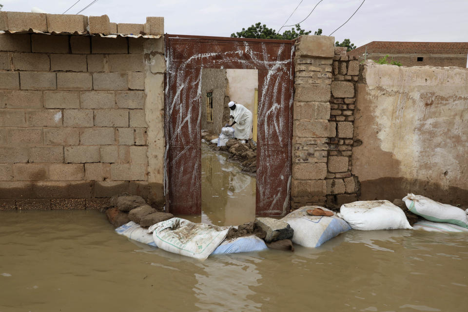 A man sets out sandbags to try to keep floodwaters from entering a house in the town of Shaqilab, about 15 miles (25 km) southwest of the capital, Khartoum, Sudan, Monday, Aug. 31, 2020. (AP Photo/Marwan Ali)