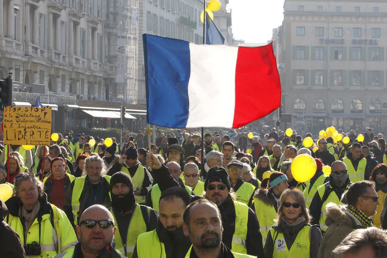 Demonstrators wearing their yellow vests demonstrate in Marseille, southern France, Saturday, Dec. 29, 2018. The yellow vest movement held several peaceful demonstrations in cities and towns around France, including about 1,500 people who marched through Marseille. (AP Photo/Claude Paris)