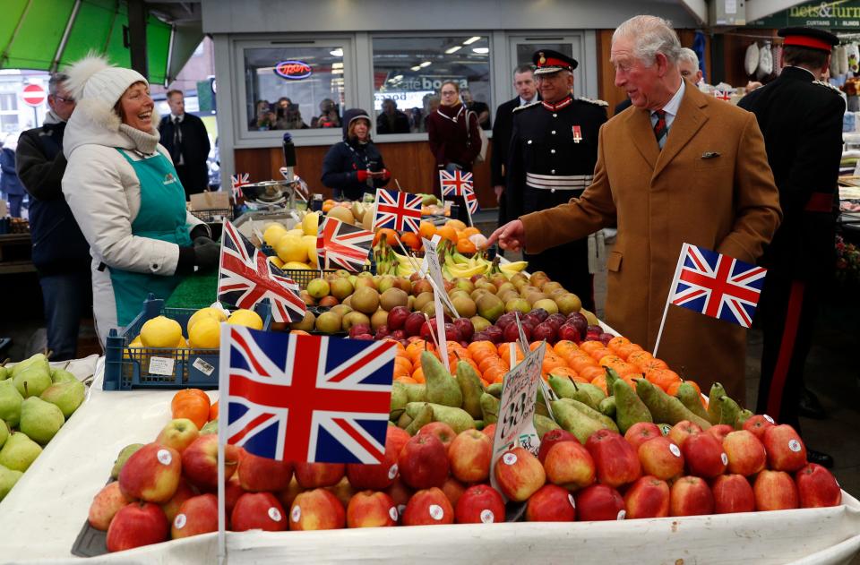 King Charles speaks with a fruit and veg stallholder in February 2020.