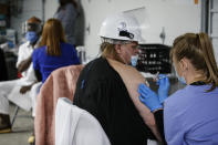 Tyson Foods team members receive COVID-19 vaccines from health officials at the Joslin, Ill., facility on Friday, Feb. 19, 2021. A growing number of companies and labor unions are directly securing coronavirus vaccines for their workers. Tyson also has expanded its on-site event to include eligible family members of employees. (John Konstantaras/AP Images for Tyson Foods)