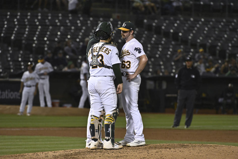 Oakland Athletics catcher Shea Langeliers (23) talks with pitcher Hogan Harris (63) on the mound during the fifth inning of the team's baseball game against the Kansas City Royals in Oakland, Calif., Tuesday, Aug. 22, 2023. (AP Photo/Nic Coury)