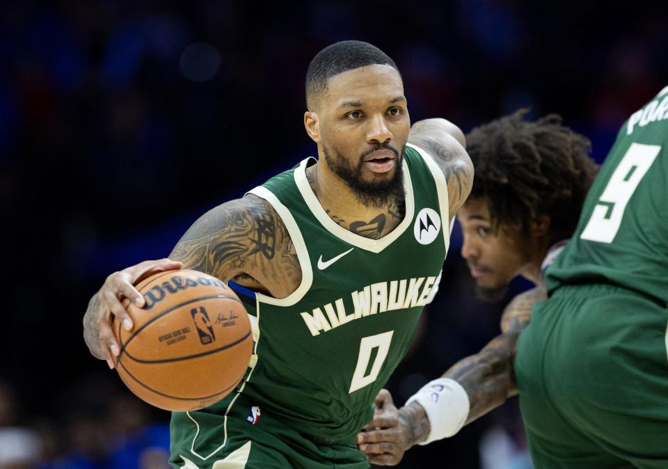 Feb 25, 2024; Philadelphia, Pennsylvania, USA; Milwaukee Bucks guard Damian Lillard (0) dribbles past Philadelphia 76ers guard Kelly Oubre Jr. (9) during the second quarter at Wells Fargo Center. Mandatory Credit: Bill Streicher-USA TODAY Sports