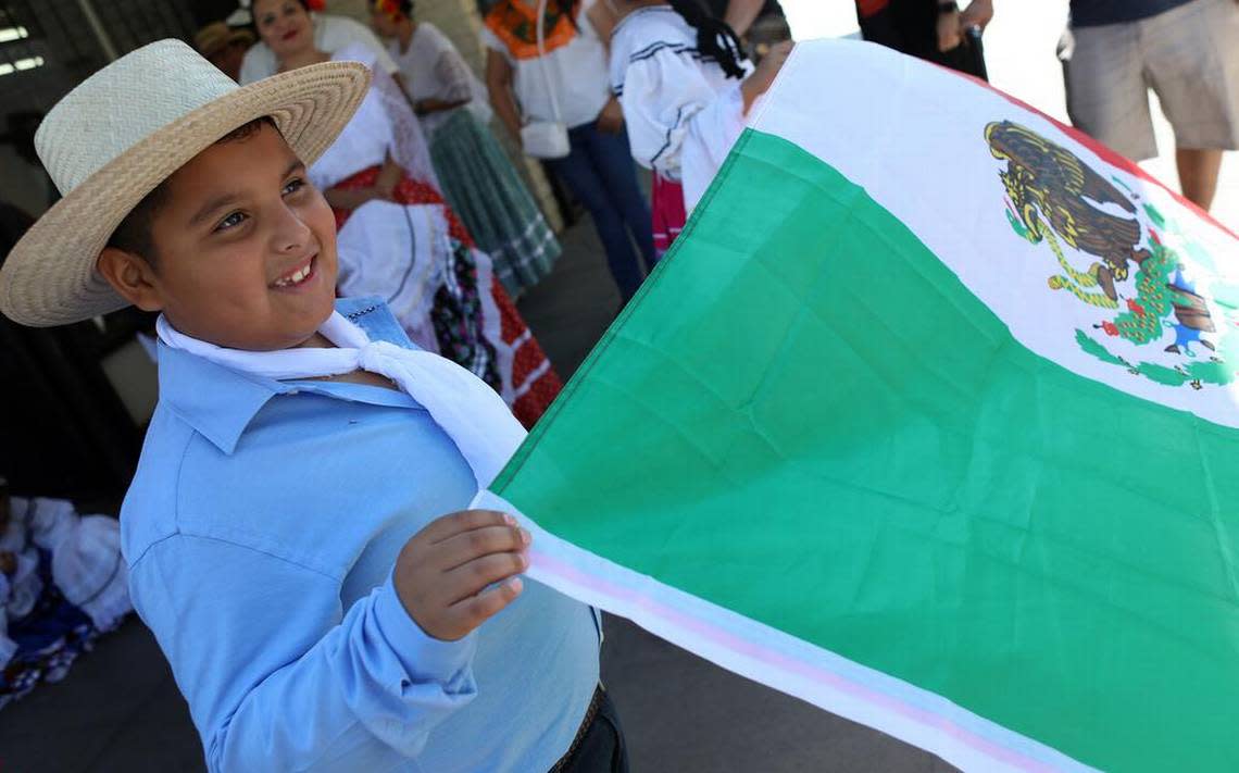 Carlos Maravilla, 7, holds the Mexican flag while waiting for the Sept. 17, 2022 parade that kicked off the Fiestas Patrias celebration in downtown Fresno.
