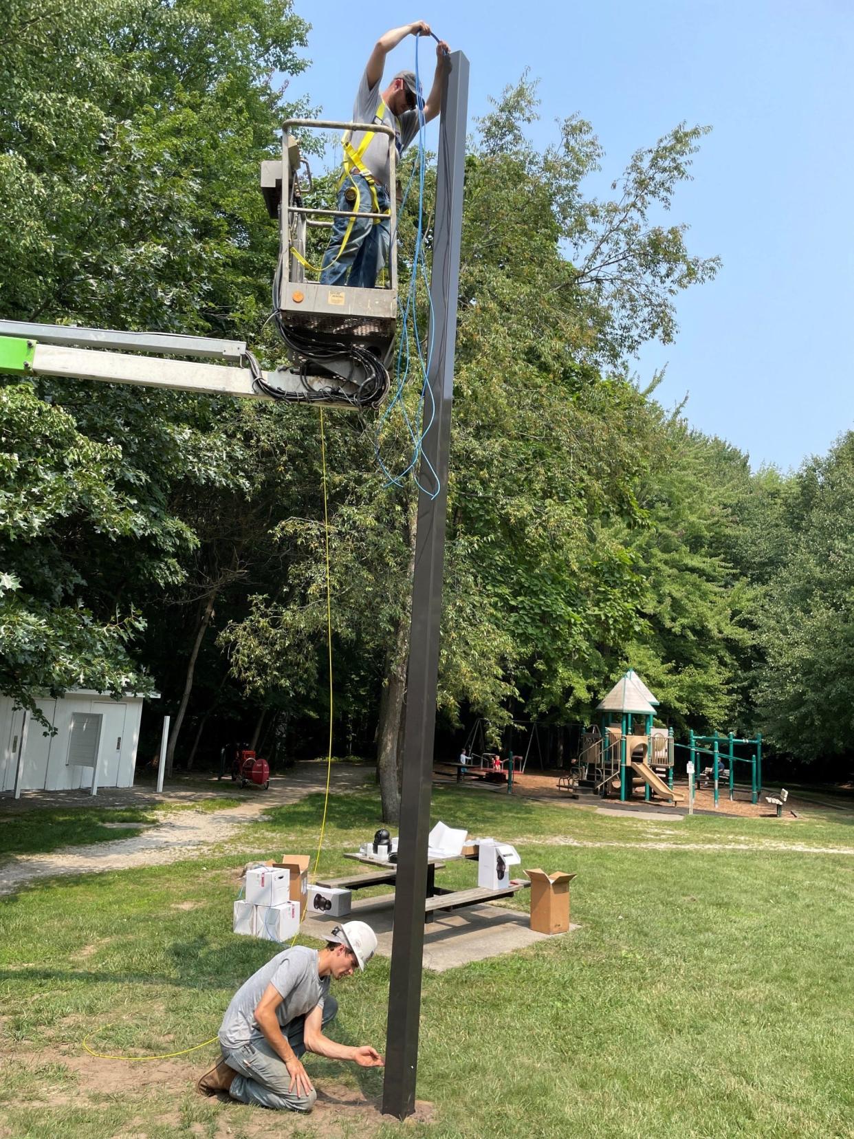 Workers from Steve Essenburg Electric of Hudsonville install cameras for Laketown Township on Tuesday, July 25, at Wolters Woods.