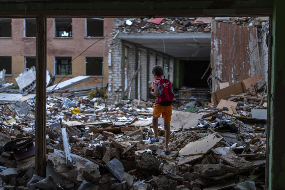 FILE - Ivan Hubenko, 11, walks on the rubble of his former Chernihiv School #21, which was bombed by Russian forces on March 3, in Chernihiv, Ukraine, Tuesday, Aug. 30, 2022. "I feel offended when I'm at my school. A resentment that the Russians destroyed my school" Ivan said. (AP Photo/Emilio Morenatti, File)