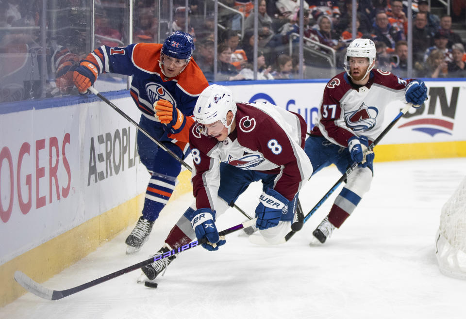 Colorado Avalanche's Cale Makar (8) and J.T. Compher (37) and Edmonton Oilers' Klim Kostin (21) compete for the puck during the second period of an NHL hockey game Saturday, Jan. 7, 2023, in Edmonton, Alberta. (Jason Franson/The Canadian Press via AP)