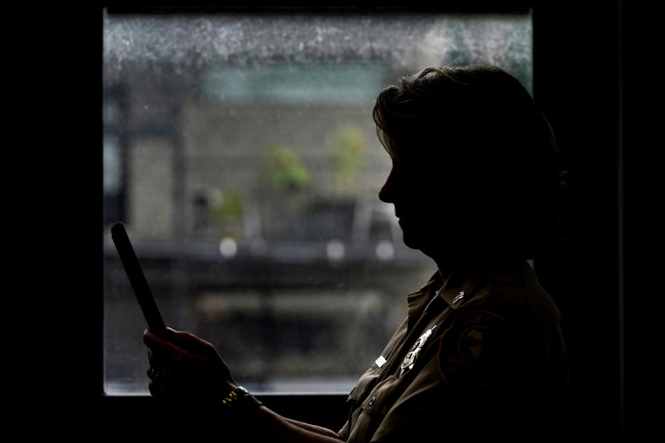 In this Friday, Aug. 13, 2021, photo Sheriff's Police Sgt. Bonnie Busching holds a tablet as she tests a virtual meeting with mental health professional at the Cook County Sheriff's Office in Chicago. The Cook County Sheriff's department officers are hitting the streets with tablets that can connect people in distress immediately with mental health professionals. And Cook County Sheriff Tom Dart says the Treatment Response Team has been successful bringing calm to the tensest of domestic situations involving people at risk of hurting themselves or others. (AP Photo/Nam Y. Huh)