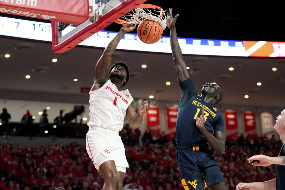 Houston guard Jamal Shead (1) dunks as West Virginia forward Akok Akok defends during the first half of an NCAA college basketball game Saturday Jan. 6, 2024, in Houston. (AP Photo/Eric Christian Smith)