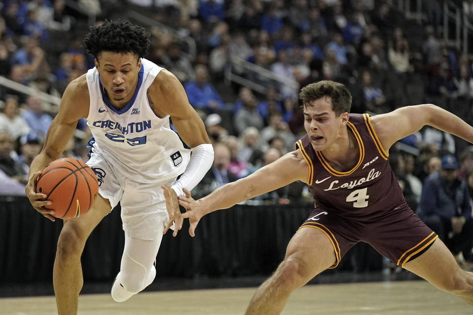 Loyola Chicago guard Braden Norris (4) tries to steal the ball from Creighton guard Trey Alexander (23) during the first half of an NCAA college basketball game Wednesday, Nov. 22, 2023, in Kansas City, Mo. (AP Photo/Charlie Riedel)