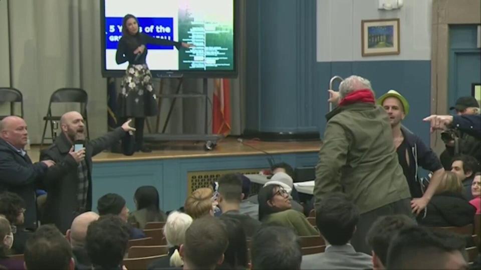 A man shouts at socialist lawmaker Alexandria Ocasio-Cortez during a town hall