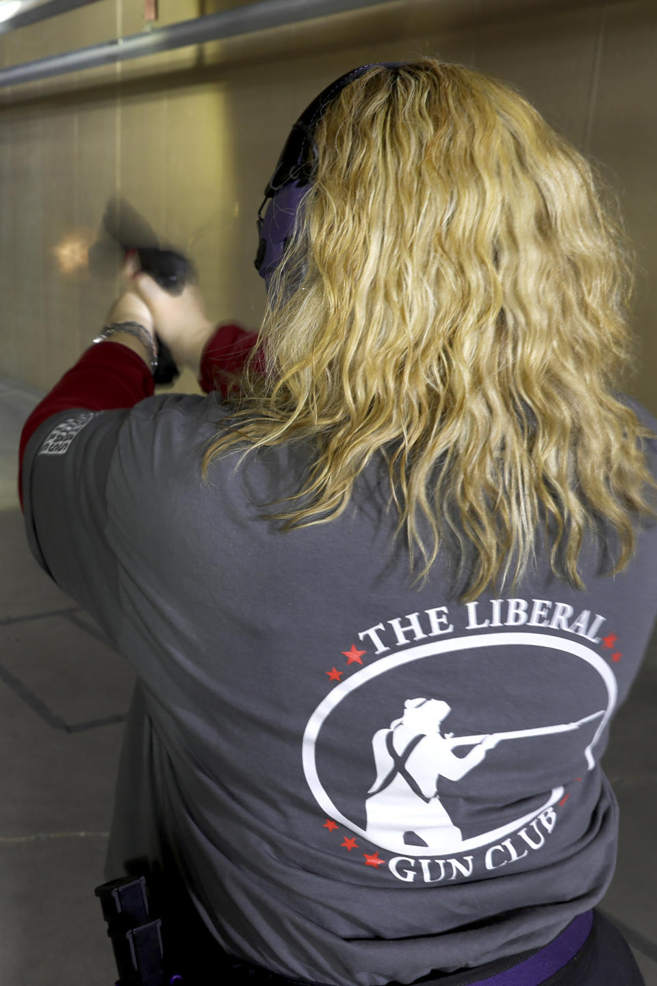 In this Wednesday, Feb. 5, 2020, photo, Kat Ellsworth of Chicago, fires her Sig Sauer P320 X-Five Legion hand gun, one of the seven guns she owns at the Caliber Tactical Gun Range in Waukegan, Ill. Ellsworth was firmly against firearms and favored gun-control until just a few years ago when she went with a friend to a gun range and discovered a love for firearms and shooting. (AP Photo/Charles Rex Arbogast)