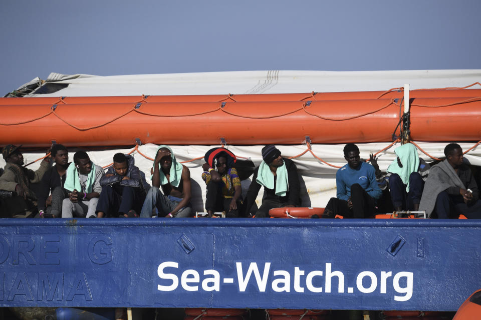 Migrants wait aboard the German humanitarian group's rescue boat Sea Watch 3, off the coast of Syracuse, Italy, Sunday, Jan. 27, 2019. The Italian coast guard is bringing socks, shoes, bread and fruit to 47 migrants who have been stranded at sea for nine days aboard a German ship. (AP Photo/Salvatore Cavalli)