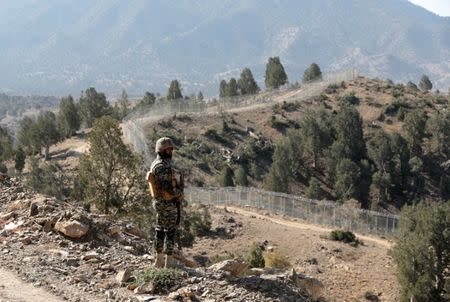 A soldier stands guard along the border fence at the Angoor Adda outpost on the border with Afghanistan in South Waziristan, Pakistan October 18, 2017. REUTERS/Caren Firouz