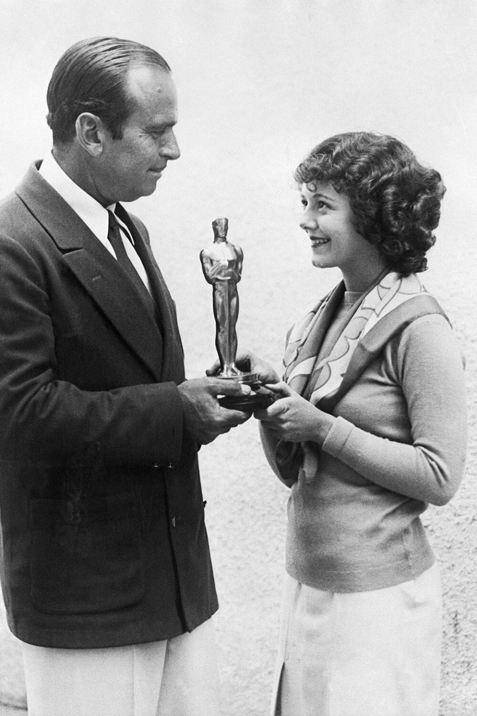Douglas Fairbanks presents Janet Gaynor with the first Academy Award for Best Actress, for her work in Seventh Heaven, as well as Street Angel, and Sunrise, at the first Academy Awards in 1929.
