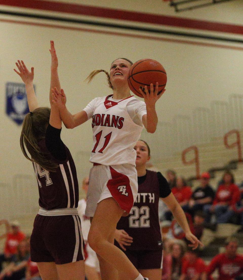 Twin Lakes junior Addie Bowsman (right) launches into the air to attempt a left handed layup against Faith Christian junior Mattea Maggio (left) on Wednesday, Dec. 27, 2023.