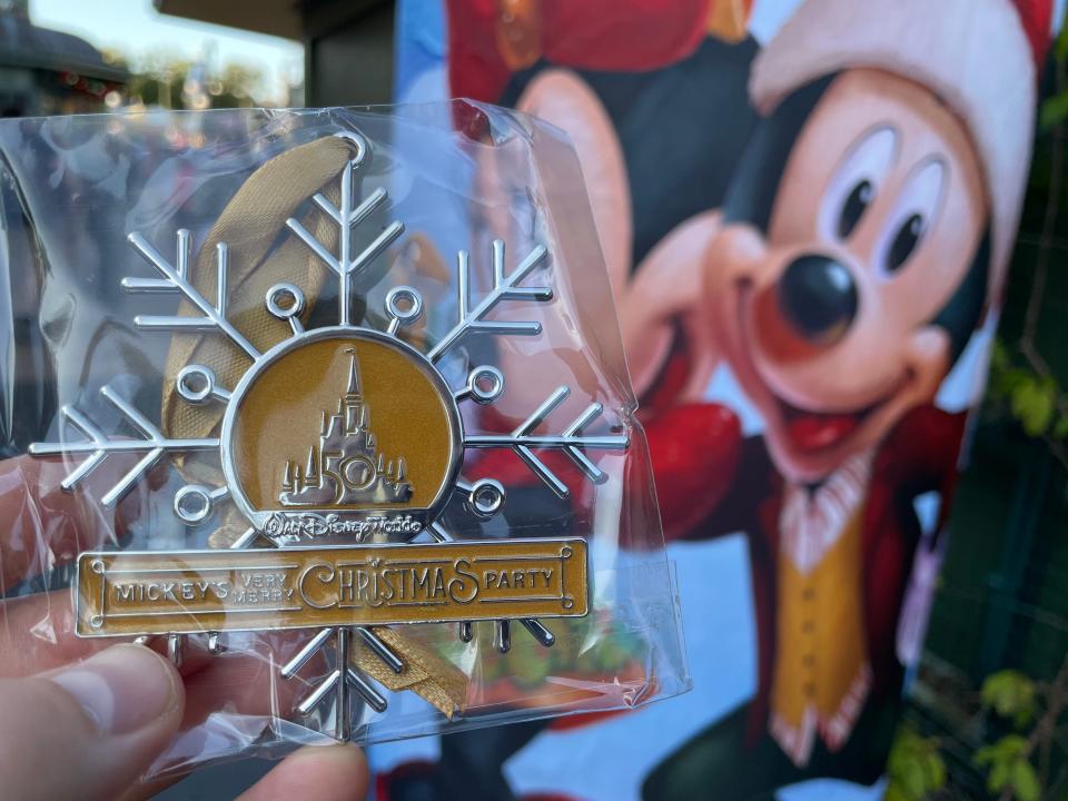 hand holding magic kingdom christmas party ornament