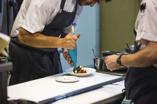 Chefs prepare food in the open kitchen of Cumulus Inc