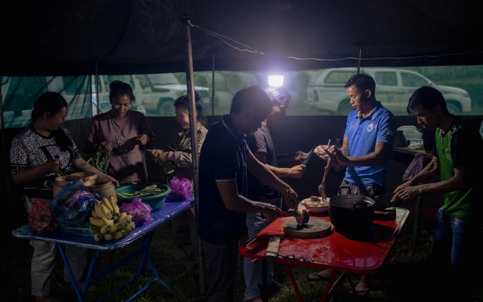 The team cook dinner after a long day working under the sweltering sun in the rice paddy field