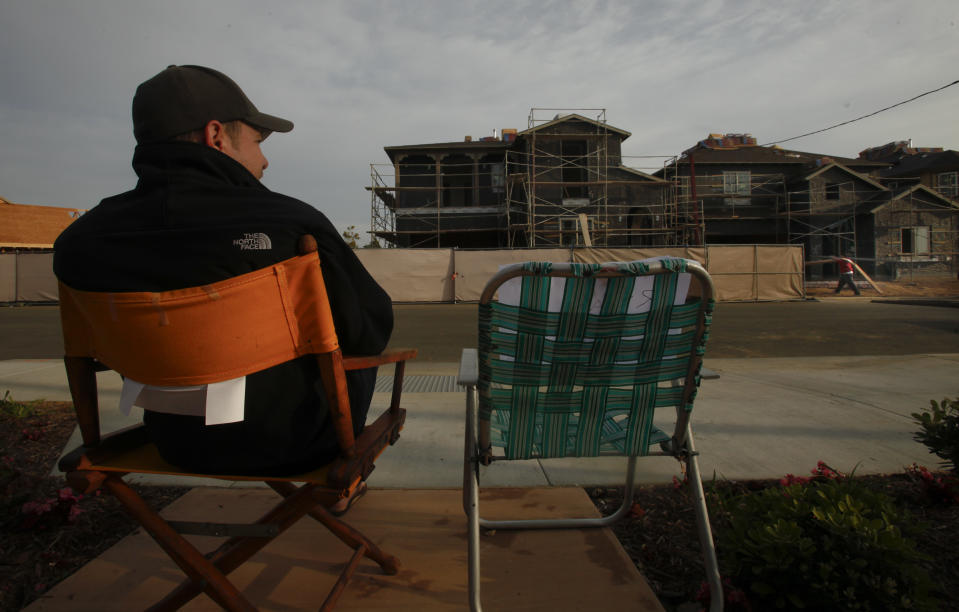 Potential home buyer Chris Thibodeau has the 12th place in line as he sits momentarily in one of the vacant chairs left by one of the others seeking to buy one of the new houses advertised in the 