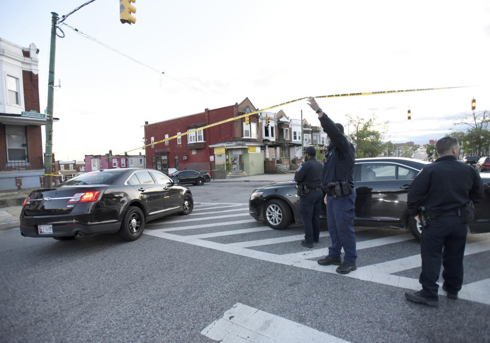 Police work near the scene where authorities say several people were shot, at least one fatally, Sunday, April 28, 2019, in Baltimore. (AP Photo/Steve Ruark)