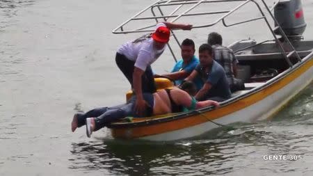 People on a boat rescue passengers of a sinking tourist ferry (not pictured) in the Guatape reservoir in Colombia June 25, 2017 in this still image taken from video obtained from social media. Juan Quiroz/via REUTERS