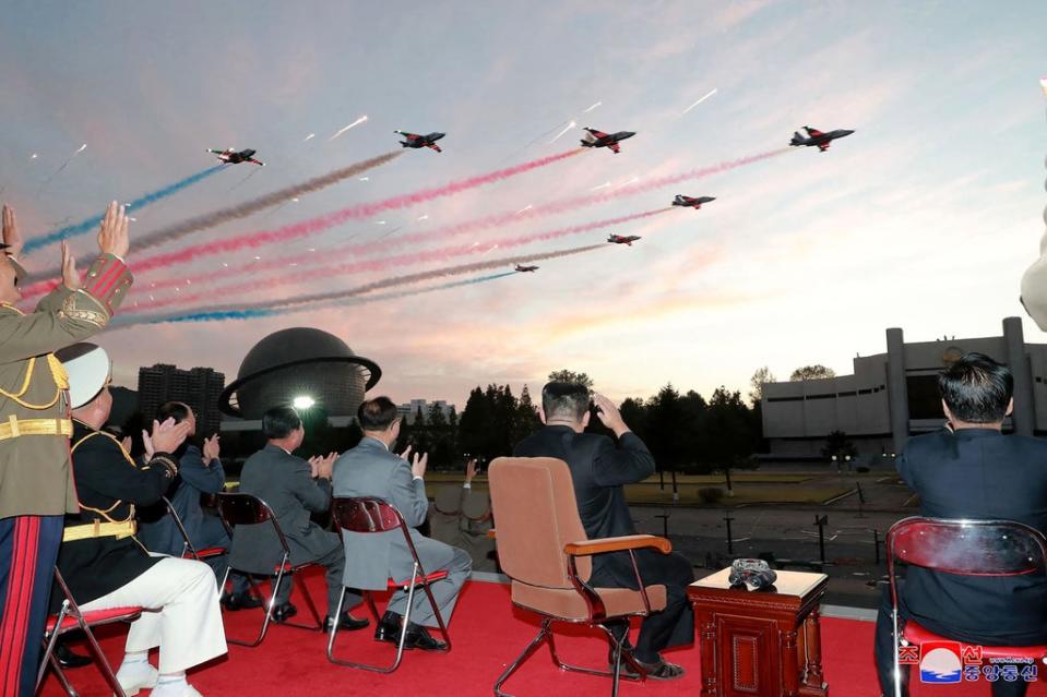 This picture taken on 11 October 2021 and released from North Korea's official Korean Central News Agency shows Kim Jong Un (2nd-R) watching a demonstration flight during the opening ceremony of the defence development exhibition (AFP via Getty Images)