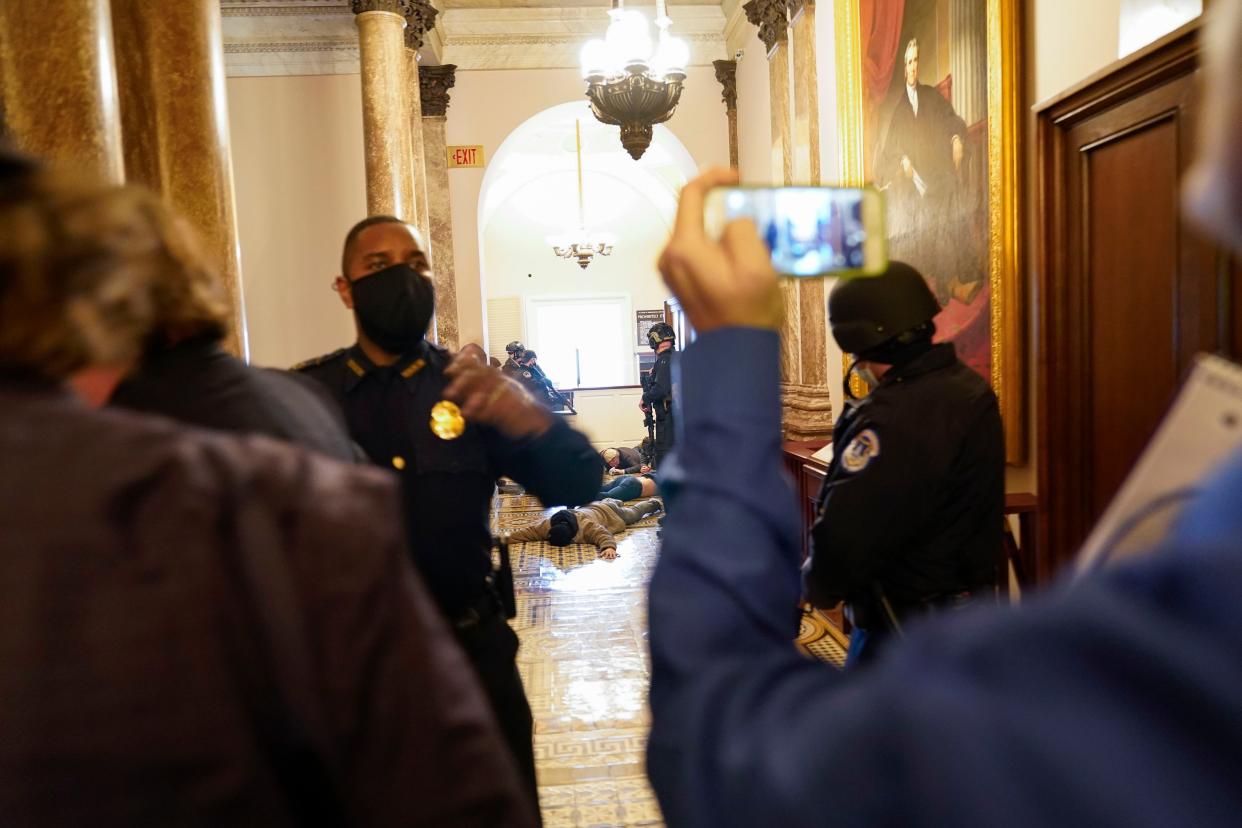 U.S. Capitol Police hold protesters on the floor at gunpoint as protesters try to break into the House Chamber at the U.S. Capitol on Wednesday, Jan. 6, 2021, in Washington.