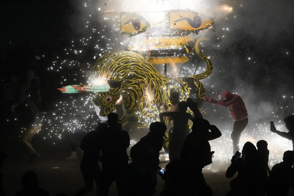 Gente baila alrededor de un enorme toro de papel maché lleno de fuegos artificiales durante el festival anual de San Juan de Dios, en Tultepec, México, el viernes 8 de marzo de 2024. (AP Foto/Marco Ugarte)