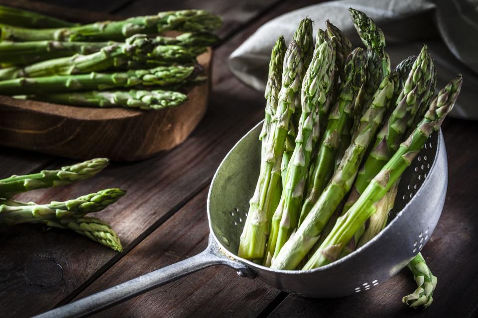 Fresh asparagus in an old metal colander