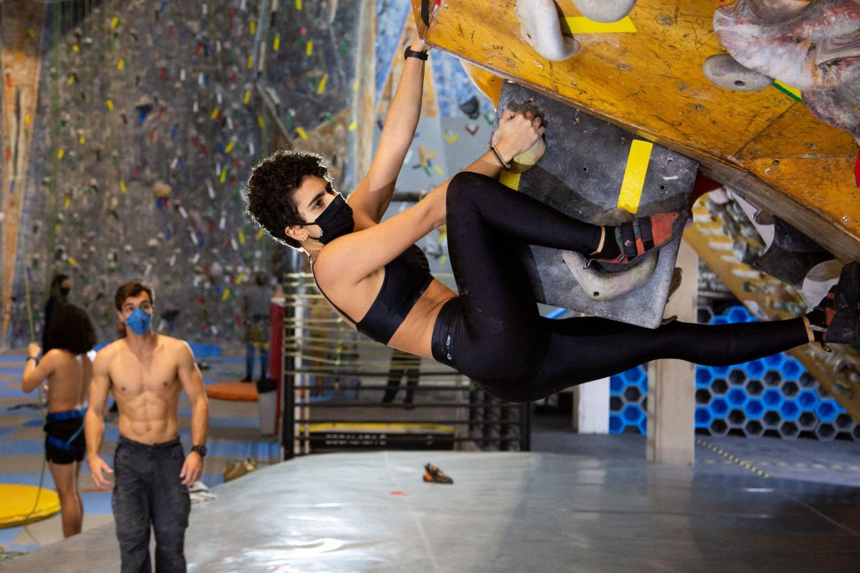 A woman wearing a face mask exercises in an indoor climbing gym amidst the coronavirus (COVID-19) pandemic on July 15, 2020 in Sao Paulo, Brazil.