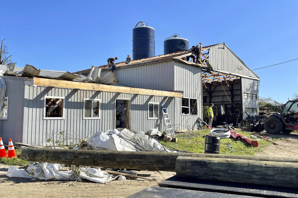 Volunteers work on the roof of a one of two building left standing at Wellacrest Farms in Mullica Hill, N.J. A tornado passes passed through the area on Wednesday, Sept. 1, 2021. (Karlie Eachus via AP)