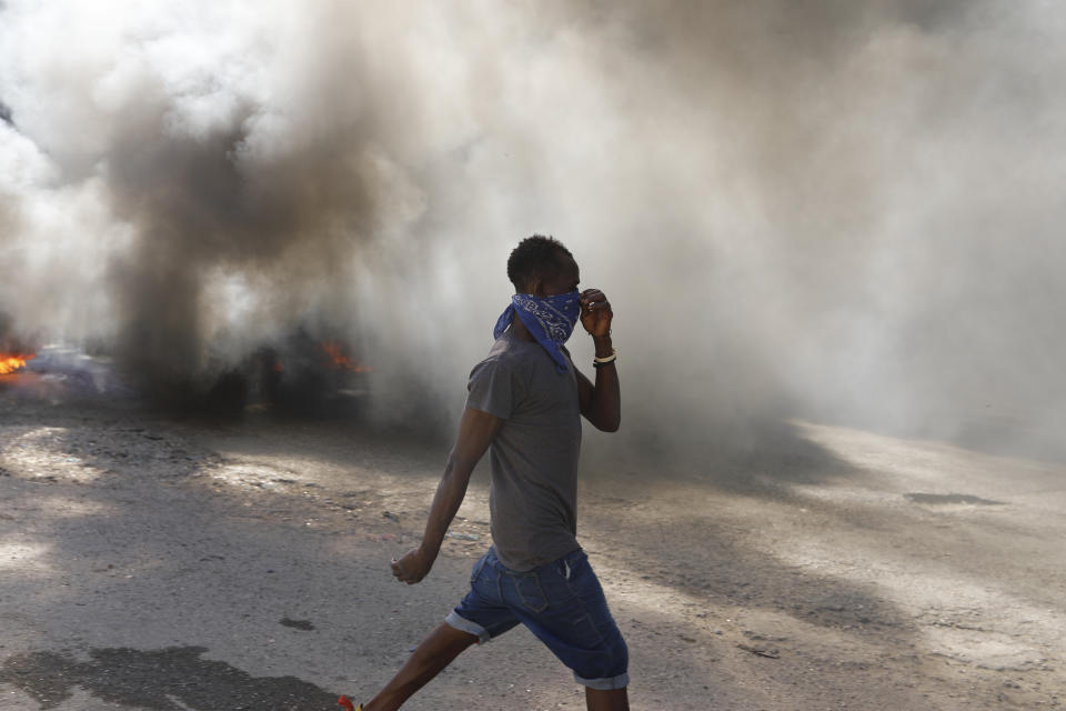 A man walks past burning tires set on fire by protesters to call attention to the country's insecurity and demanding the resignation of the prime minister, in Port-au-Prince, Haiti, Thursday, Jan. 18, 2024. (AP Photo/Odelyn Joseph)