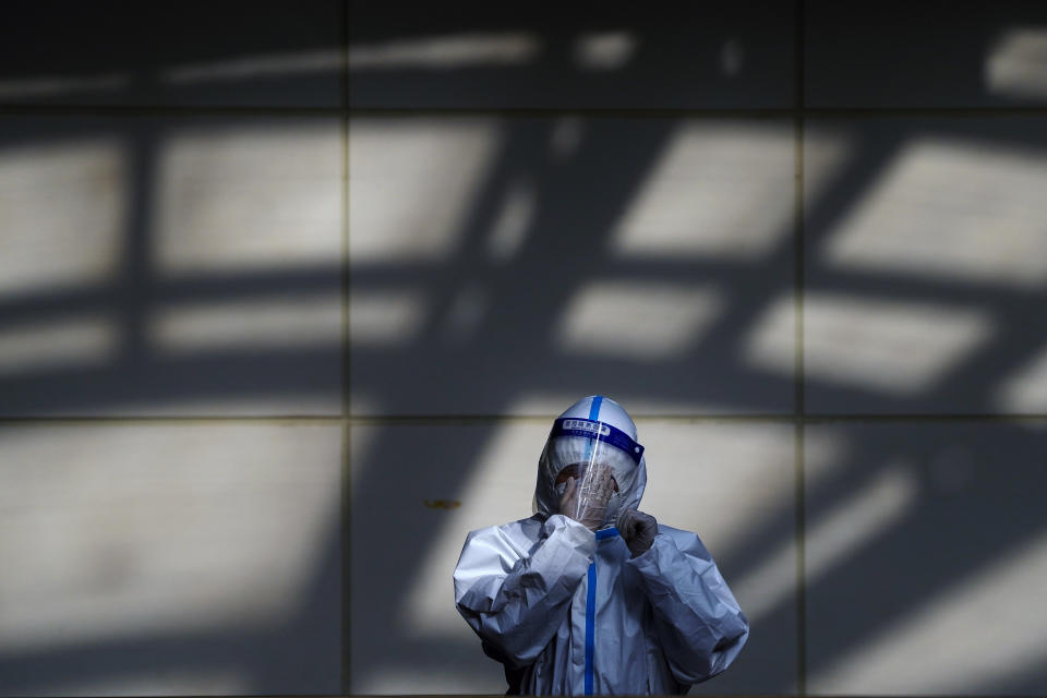 A worker in protective suit wipes his face shield at a coronavirus testing side in Beijing, Monday, Dec. 5, 2022. China is easing some of the world's most stringent anti-virus controls and authorities say new variants are weaker. But they have yet to say when they might end a "zero-COVID" strategy that confines millions of people to their homes and set off protests and demands for President Xi Jinping to resign. (AP Photo/Andy Wong)