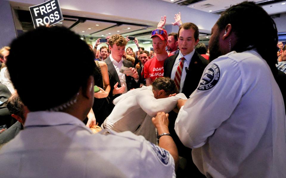 An audience member is removed by private security as Donald Trump speaks