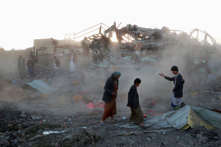 People walk at the site of an air strike in the northwestern city of Saada, Yemen November 1, 2017. REUTERS/Naif Rahma