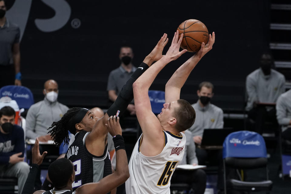 Sacramento Kings center Richaun Holmes, left, challenges the shot of Denver Nuggets center Nikola Jokic, right, during the first half an NBA basketball game in Sacramento, Calif., Saturday, Feb. 6, 2021. (AP Photo/Rich Pedroncelli)