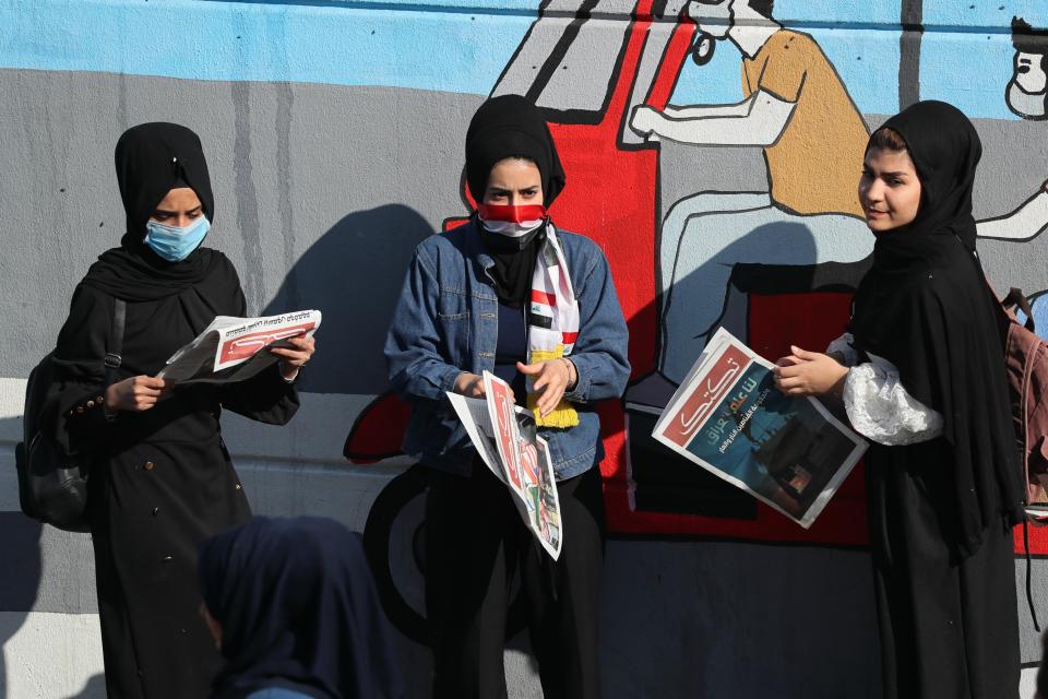 Protesters read copies of “Tuk Tuk” newspapers, in Tahrir Square, Baghdad, Iraq, Wednesday, Nov. 20, 2019. A small group of Iraqi volunteers is working in secrecy to produce the newspaper that aims to be the voice of the largest grassroots protest movement in the country’s modern history. Its editors say the newspaper is vital amid shutdowns of the internet, filling a void left by mainstream Iraqi journalists who either back the government or fear retaliation. (AP Photo/Hadi Mizban)