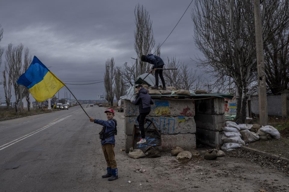 FILE - Ukrainian children play at an abandoned checkpoint in Kherson, southern Ukraine, Nov. 23, 2022. (AP Photo/Bernat Armangue, File)