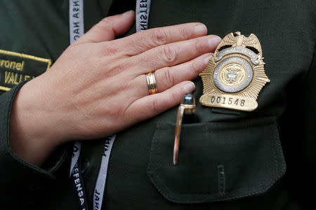 A member of the police places her hand over her chest while singing the national anthem during a rally against violence, following a car bomb explosion, in Bogota, Colombia January 20, 2019. REUTERS/Luisa Gonzalez