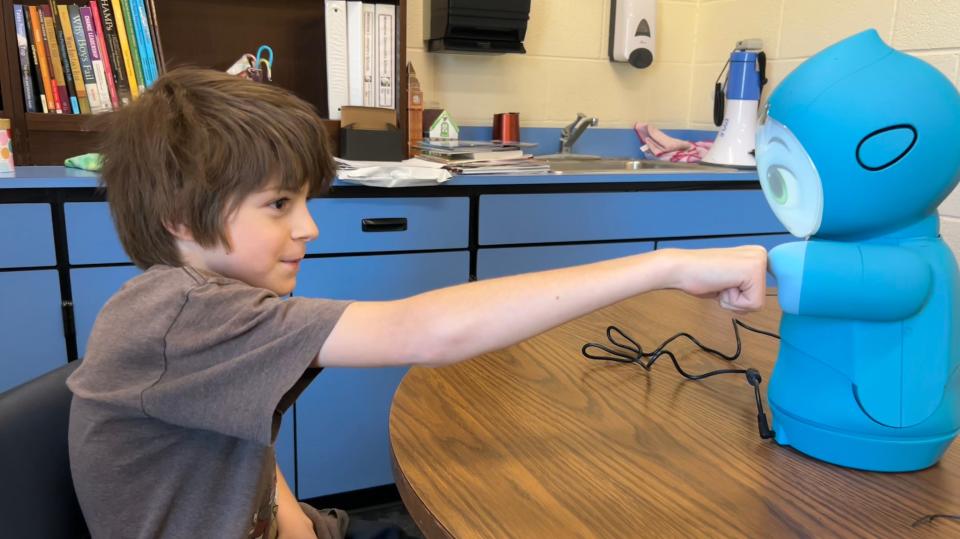 Wolverine third grader William Trugillo practices using the Moxie robot the district is introducing.