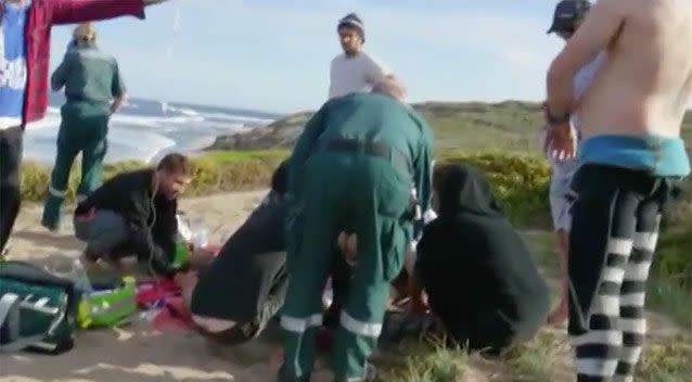 Paramedics and fellow surfers rush to the beach to help the father of two. Source: 7 News